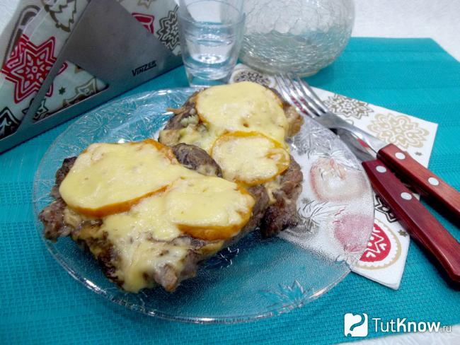 Готовые отбивные из свинины на сковороде с помидорами и сыром