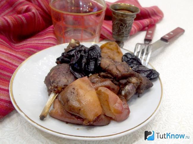 Готовая запеченная утка кусочками с яблоками и черносливом в соевом соусе