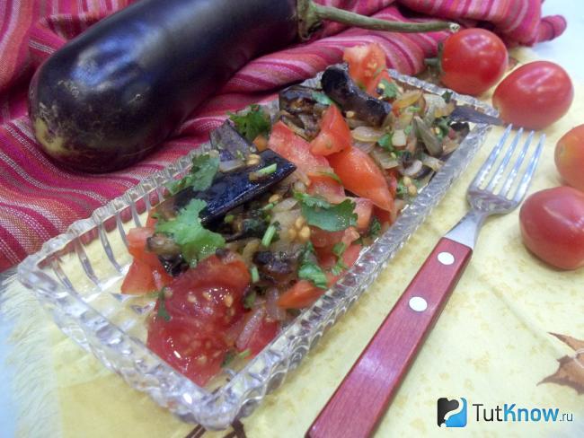 Готовый салат из жареных баклажанов с луком и помидорами