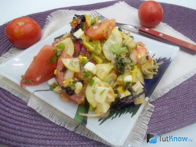Готовый салат с помидорами, огурцами, чесноком и яйцами