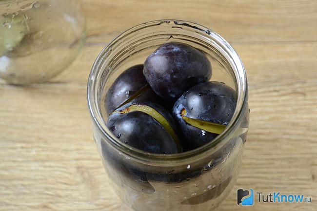 Сливы с чесноком уложены в банки