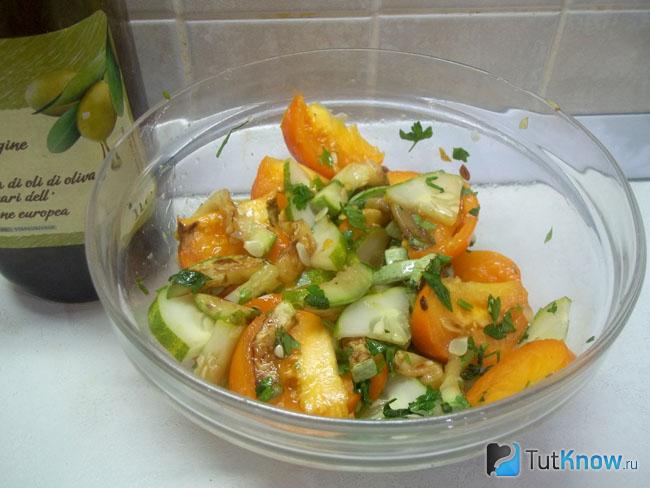 Готовый салат с жареными кабачками, помидорами и огурцами
