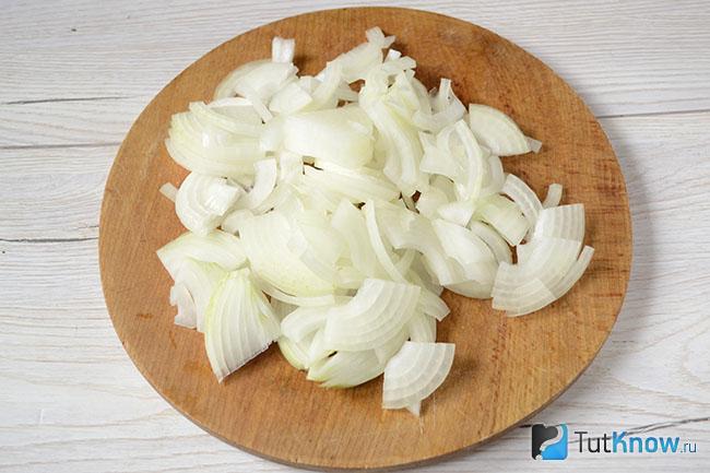 Нарезанный репчатый лук на кухонной дощечке