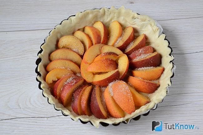 Дольки персиков присыпаны сахаром и корицей