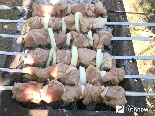 Мясо жарится на углях
