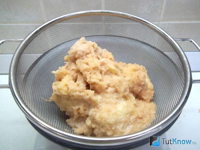 Натертый картофель с луком переложены в сито, чтобы стекла жидкость
