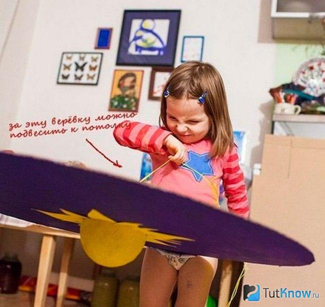 Девочка держится за верёвку макета