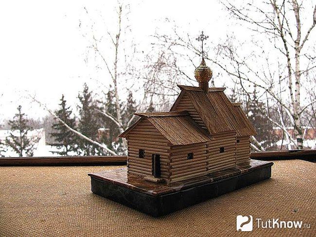 Макет церкви из спичек стоит на улице