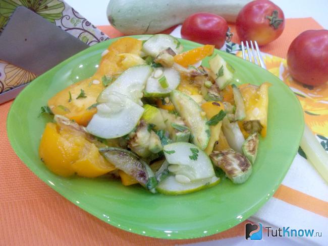 Готовый салат с жареными кабачками, помидорами и огурцами