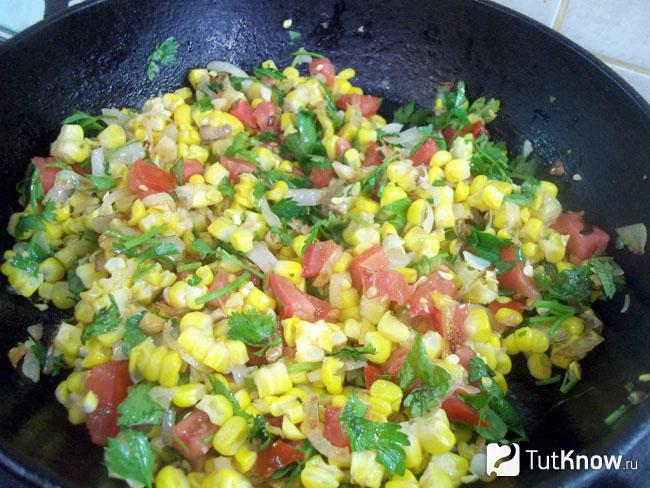 Готовая жареная кукуруза с луком и помидорами