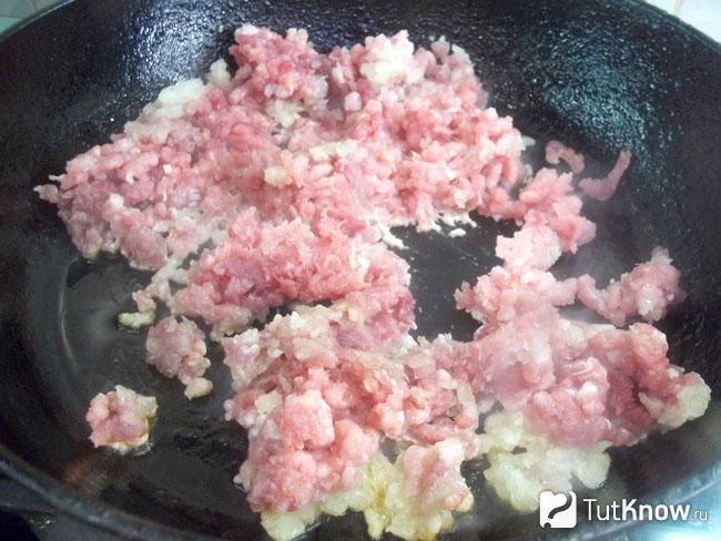 В сковороде жарится мясо с луком