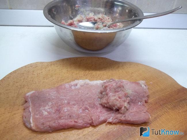 Фарш выложен на куски отбитого мяса