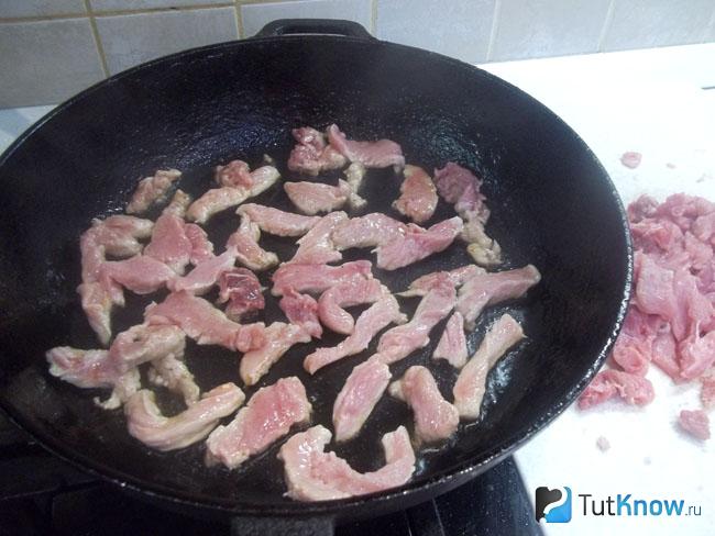 Мясо нарезано соломкой и жарится в сковороде