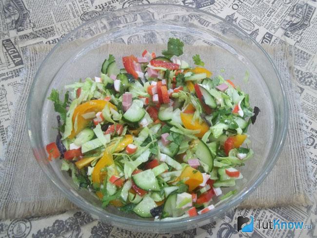 Готовый салат с колбасой, крабовыми палочками, капустой и помидорами