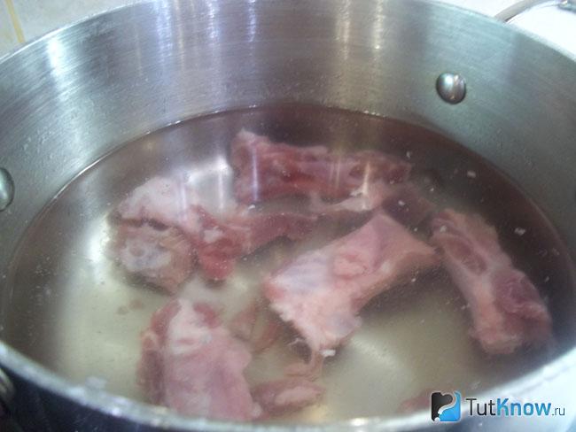 Ребра опущены в кастрюлю и залиты водой
