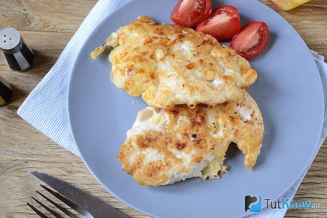 Куриные отбивные в сырном кляре выложены на тарелке