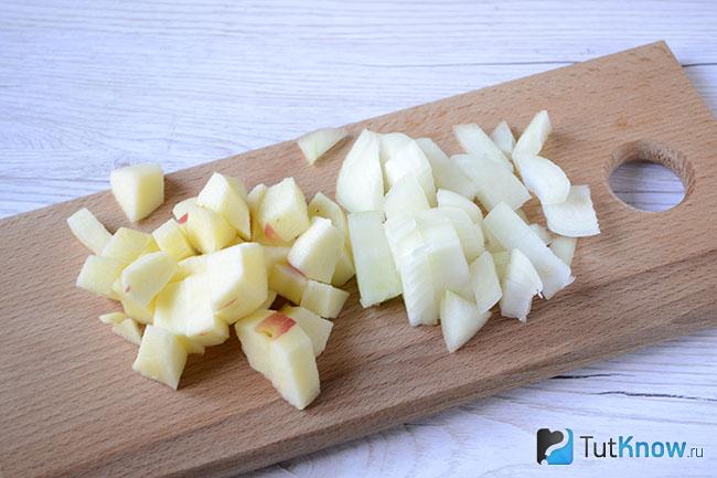 Нарезанные яблоки и лук на кухонной доске