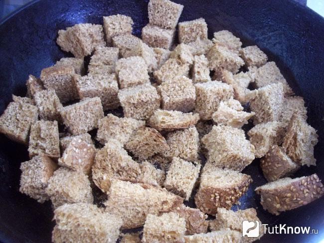В сковороду выложены кусочки хлеба