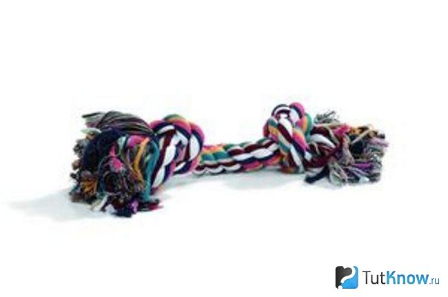 Игрушка для собаки из разноцветного каната на белом фоне