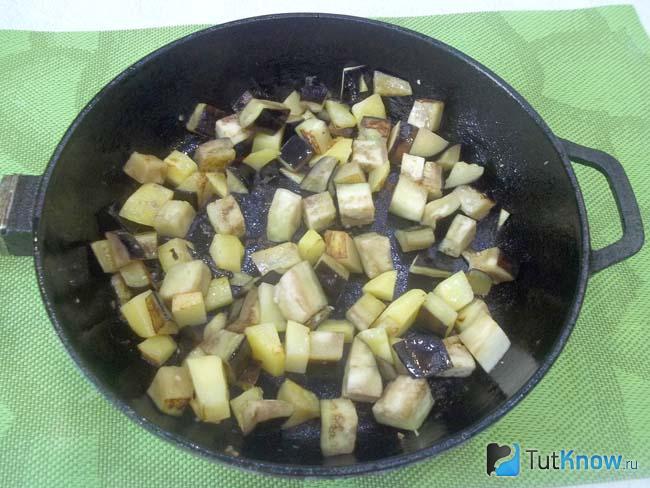 В сковороде жарятся нарезанные кубиками баклажаны