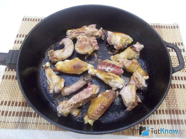 Курица нарезана кусочками и жарится в сковороде