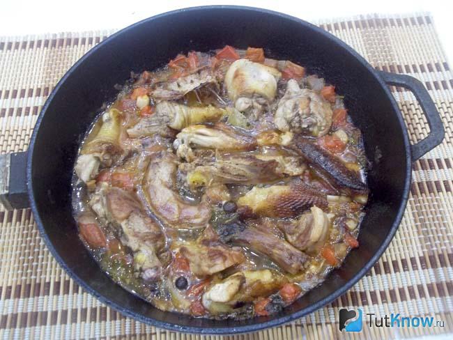 Готовая курица тушеная с помидорами, луком и зеленью
