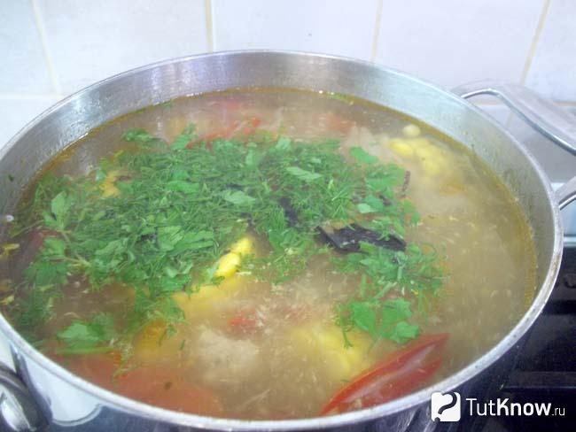 В готовый куриный суп с кукурузой, сладким перцем и капустой добавлена зелень