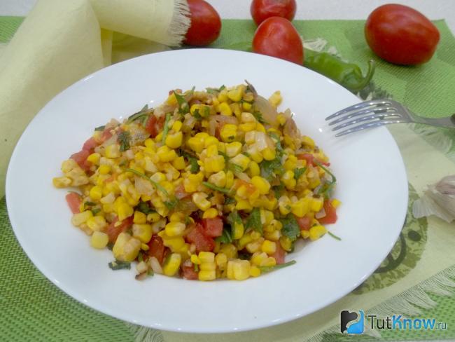 Готовая жареная кукуруза с луком и помидорами