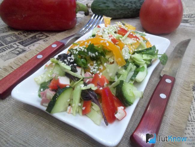 Готовый салат с колбасой, крабовыми палочками, капустой и помидорами