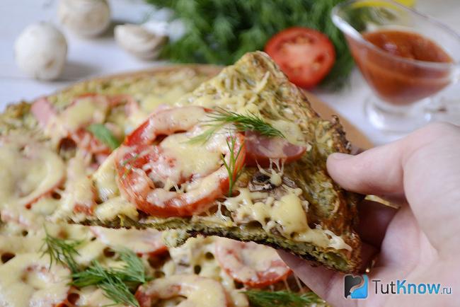 Кусочек кабачковой пиццы с помидорами и колбасой