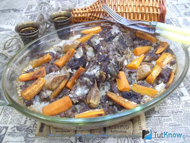 Готовая запеченная свинина с рисом, морковью и чесноком