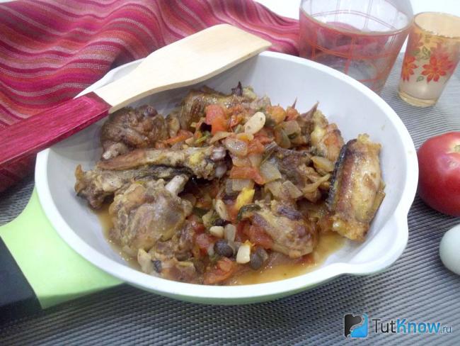 Готовая курица тушеная с помидорами, луком и зеленью