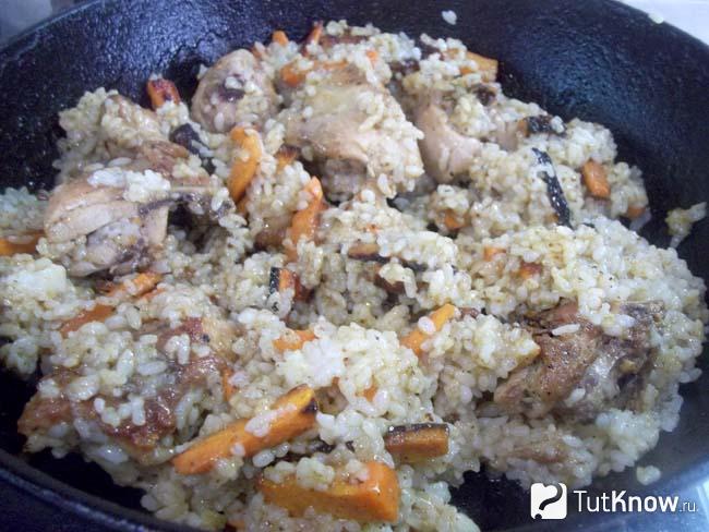 Готовые куриные бедрышки, тушеные с рисом и морковью