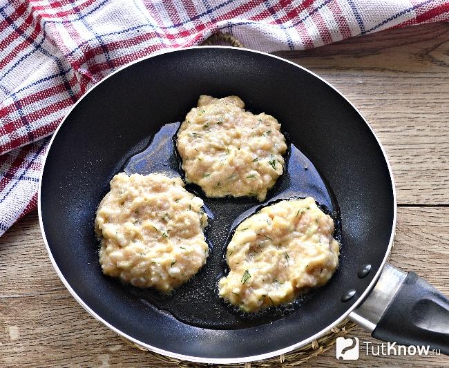 Оладьи из куриной грудки жарятся на сковороде