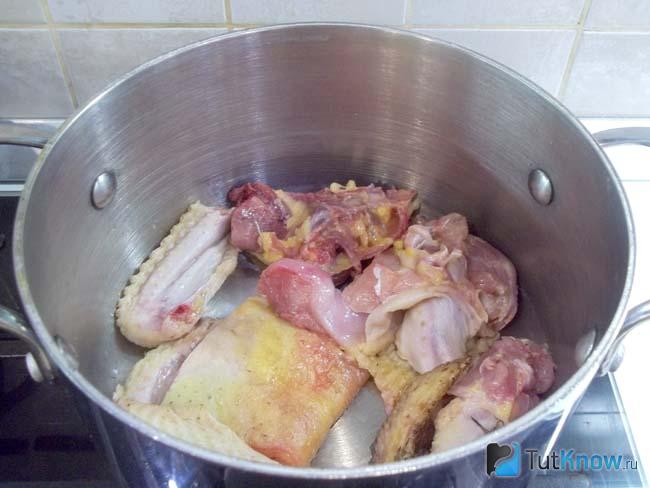 Курица нарезана кусочками и сложена в кастрюлю