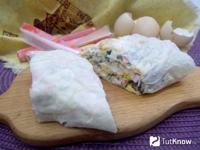 Готовый рулет из лаваша с крабовыми палочками, яйцами, сыром и зеленью