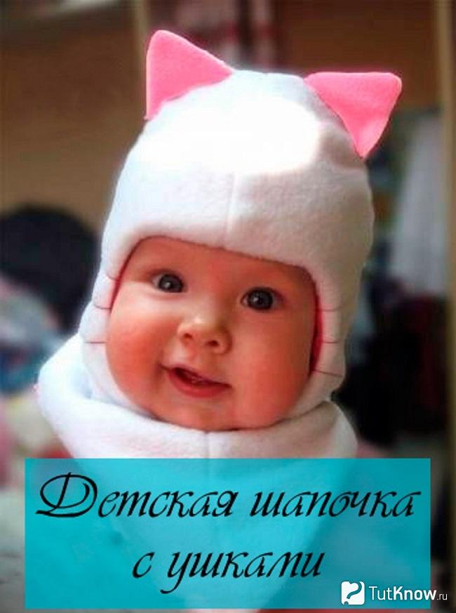 Ребёнок в шапке с розовыми ушками