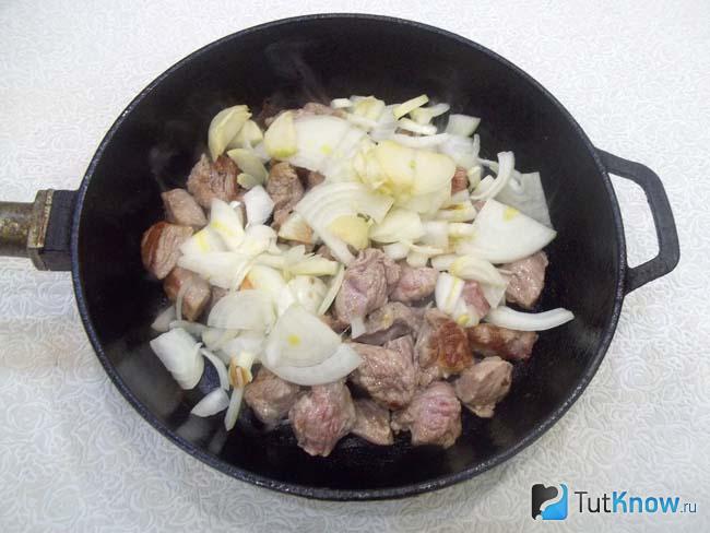 В сковороду к мясу добавлен нашинкованный лук