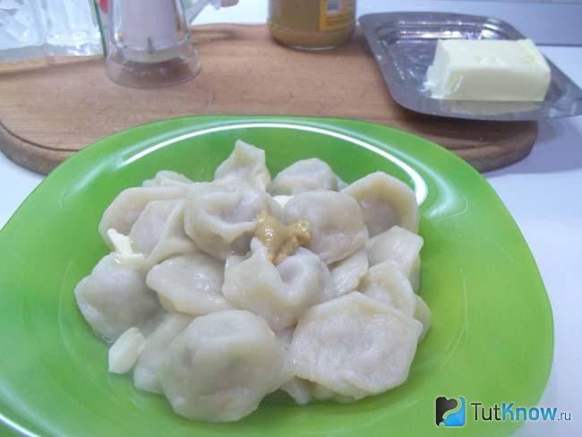 Отваренные пельмени приправлены горчицей и уксусом