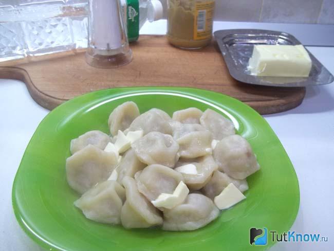 Отваренные пельмени приправлены маслом