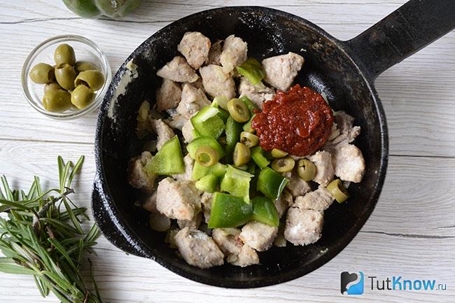 Добавление овощей и томатной пасты к мясу на сковороде