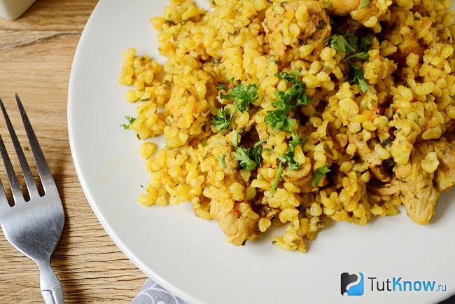 Булгур с мясом и томатным соком на тарелке