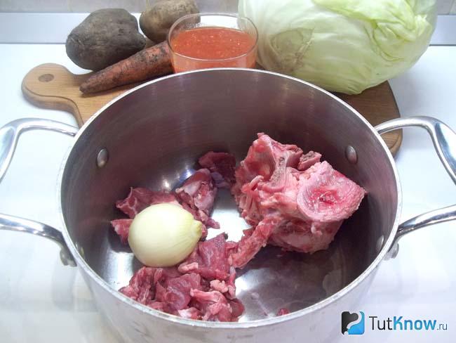 Мясо с луковицей сложено в кастрюлю