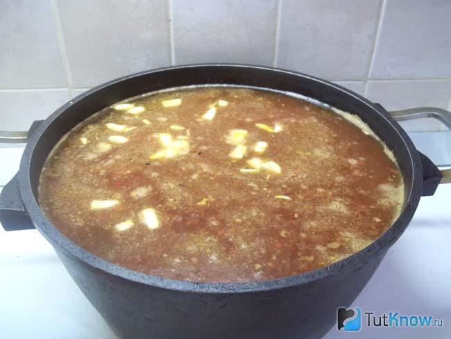 Продукты залиты водой, приправлены специями и суп варится до готовности