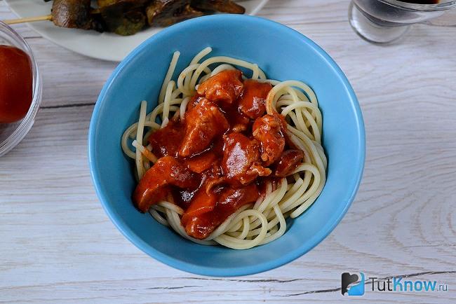Макароны с томатной подливой и мясом в тарелке