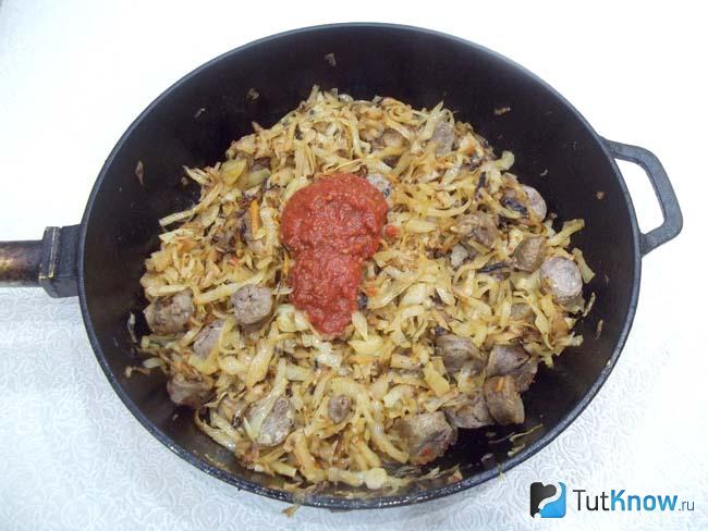 В сковороду с капустой и колбасками добавлен томат