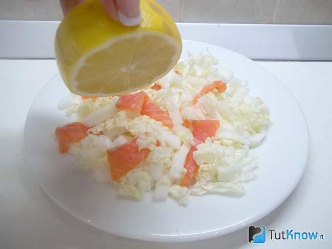 Салат с пекинской капустой и красной рыбой приправлен лимонным соком и малом