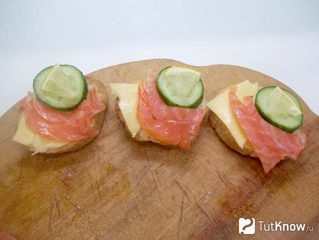 Готовые бутерброды с красной рыбой, сыром, огурцом и лимоном