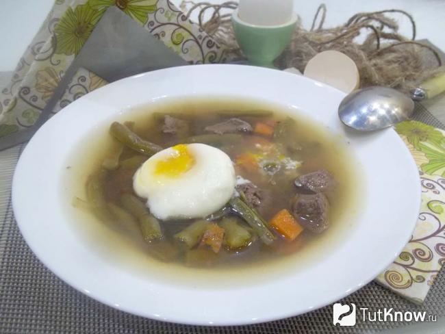 Готовый суп с печенью, стручковой фасолью и яйцом-пашот
