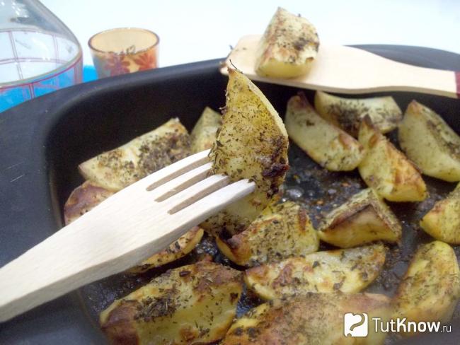 Готовый картофель запеченный в духовке дольками с итальянскими специями
